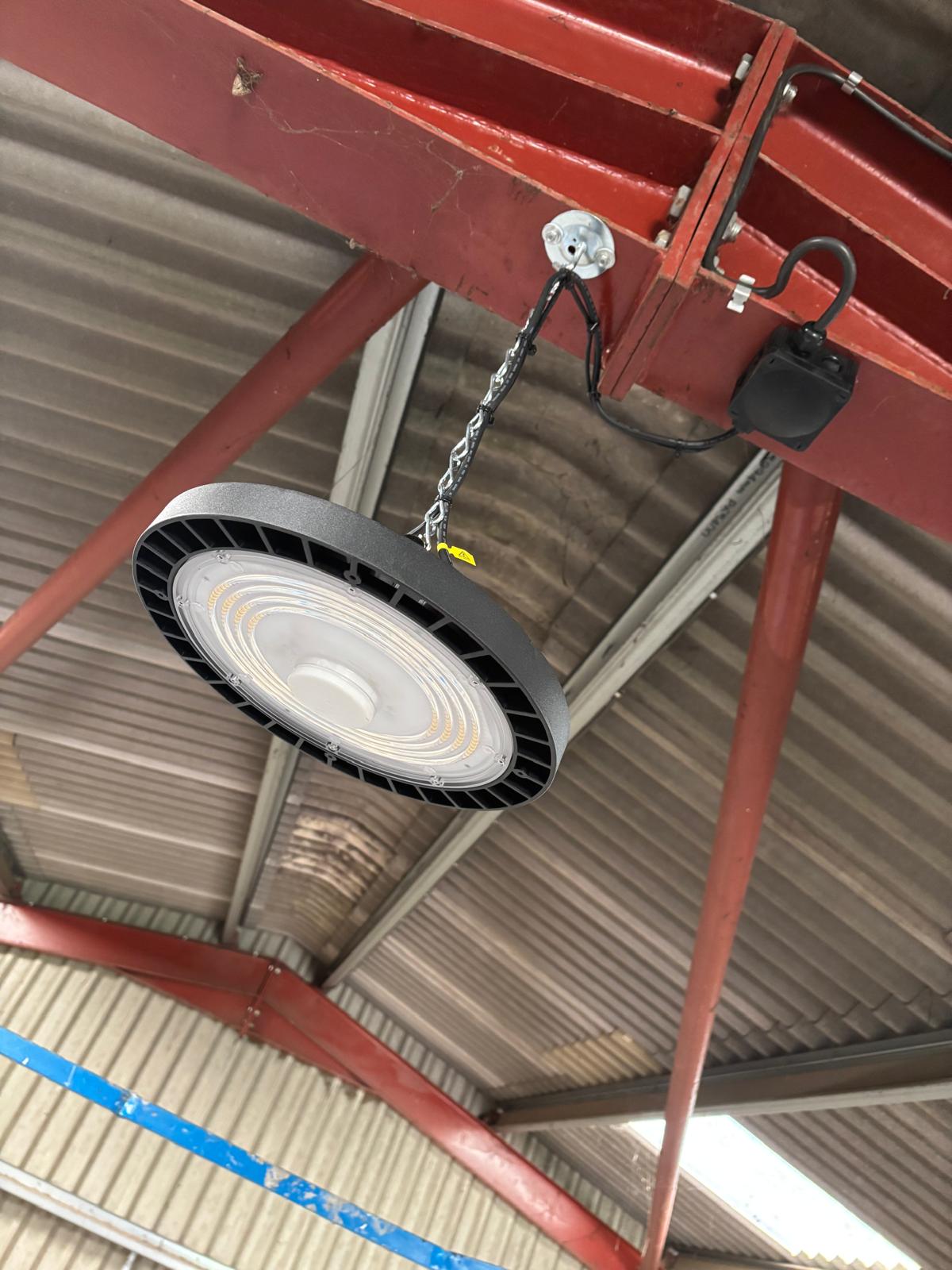 Commercial high-bay LED light beneath a steel warehouse roof