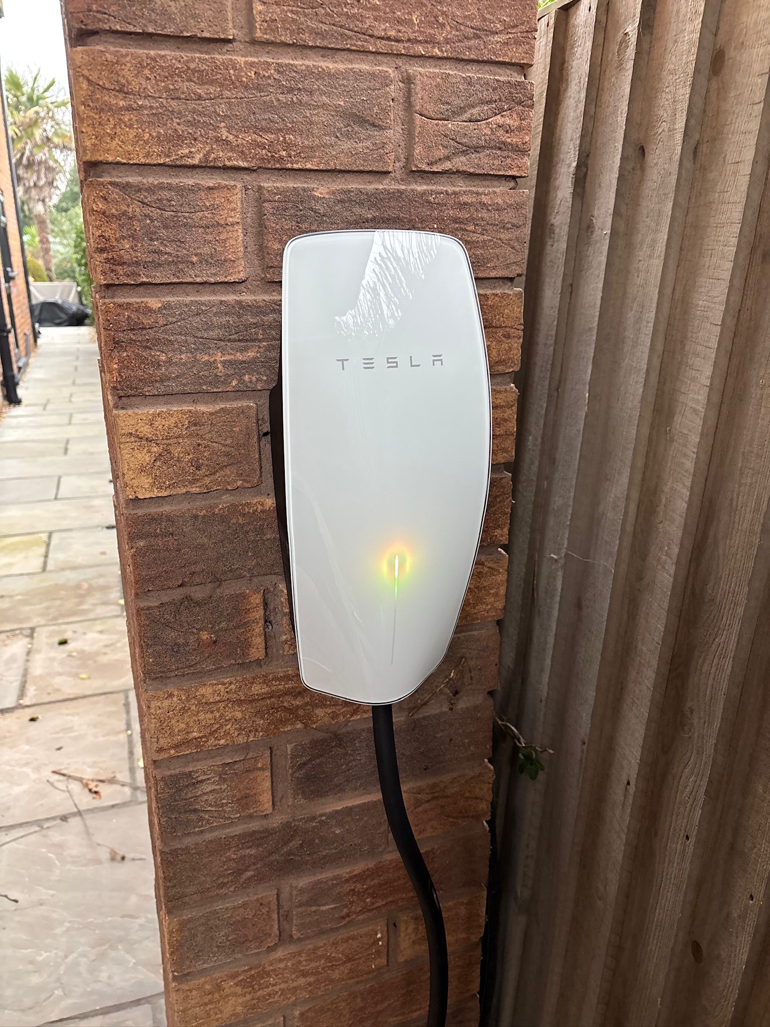 Tesla wall connector installed on a brick exterior
